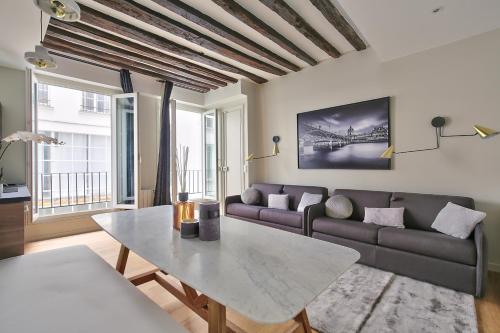 un salon avec un canapé et une table dans l'établissement 70 - Authentic Parisian Flat, à Paris