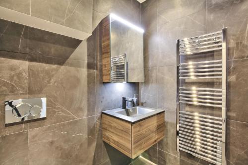 une salle de bain avec un lavabo et un miroir dans l'établissement 70 - Authentic Parisian Flat, à Paris