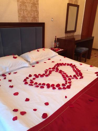 a bunch of red rose petals on a bed at Atlas Hotel in Ulaanbaatar