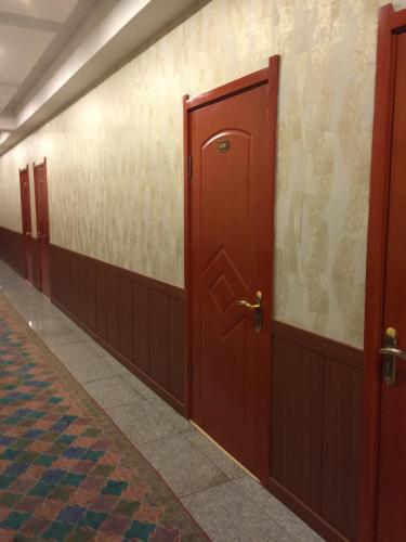 a row of red doors in a hallway at Atlas Hotel in Ulaanbaatar
