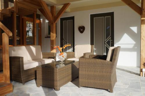 a patio with wicker chairs and a glass table at Apartment Bad Kleinkirchheim in Bad Kleinkirchheim