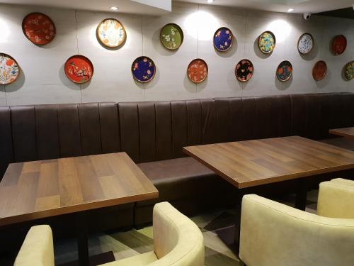 a restaurant with tables and plates on the wall at Klase Hotels in Chennai