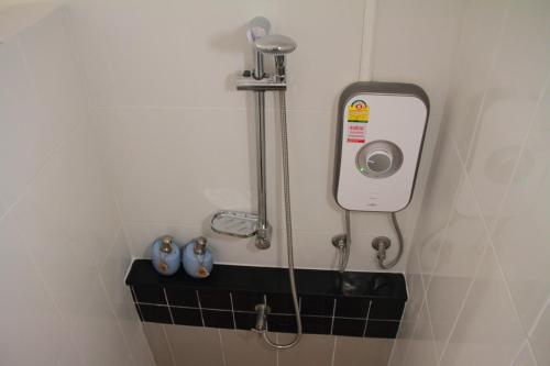 um chuveiro na casa de banho com uma câmara na parede em Baansukhita em Laem Sing