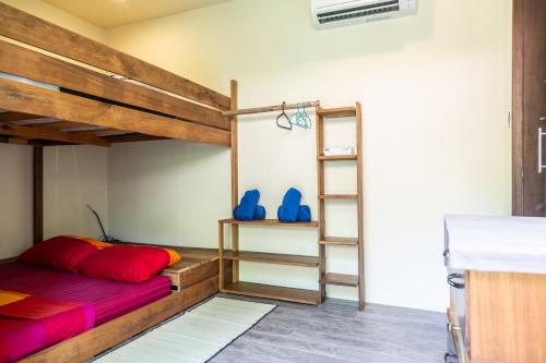 1 dormitorio con litera con almohadas rojas y zapatos azules en Baan Manaao, en Hinkong