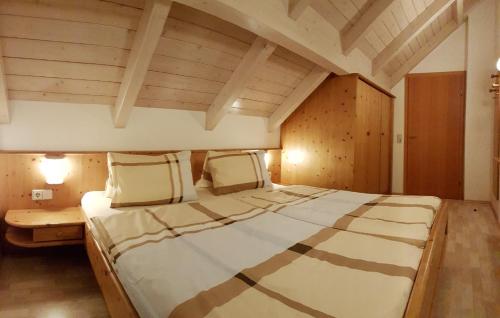 Cama grande en habitación con techo de madera en Ranner's Ferienwohnung, en Hermagor