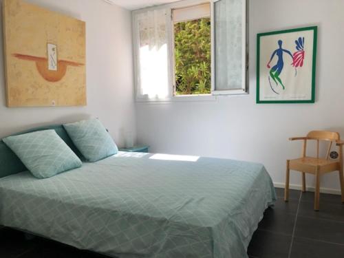 um quarto com uma cama, uma janela e uma cadeira em Appartement les Pieds dans l'eau ! em Le Lavandou