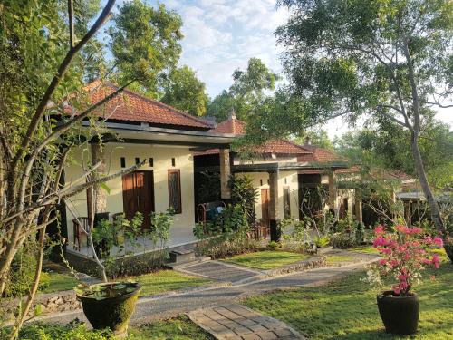 a house with a garden in front of it at Tregge Surf Camp Uluwatu in Uluwatu