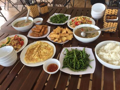 a table full of different types of food on plates at Sunshine Homestay in Phong Nha