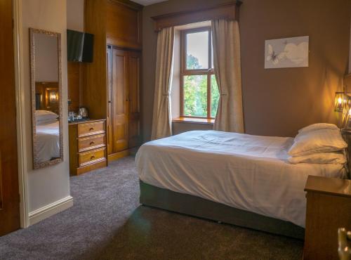 a bedroom with a bed and a window and a mirror at Crown & Anchor Inn in Brough