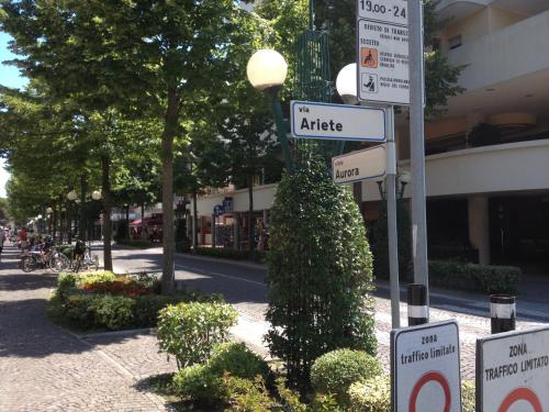 a street sign on a pole with street signs at Adriella apartments in Bibione