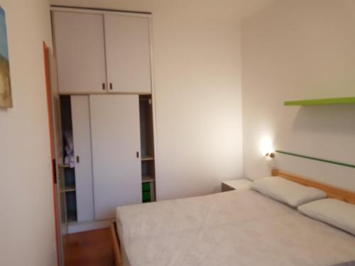 a small bedroom with a bed and a cabinet at Adriella apartments in Bibione