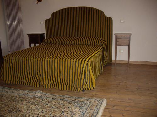 a bed with a yellow and black striped blanket at Agriturismo Il Borgo Degli Ulivi in Roseto degli Abruzzi