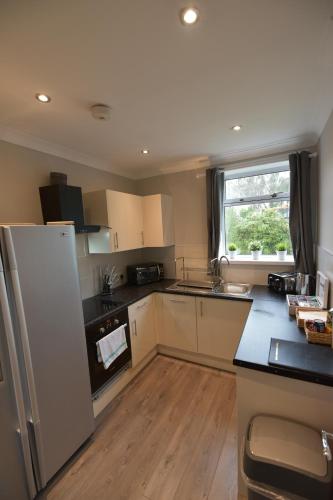 a kitchen with a refrigerator and a counter top at Sighthill 3 Bedrooms with Private Garden in Edinburgh