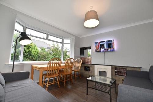 a living room with a couch and a table and chairs at Sighthill 3 Bedrooms with Private Garden in Edinburgh