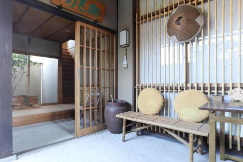 a room with two chairs and a bench in a building at Konuka Yakushi Temple House in Kyoto