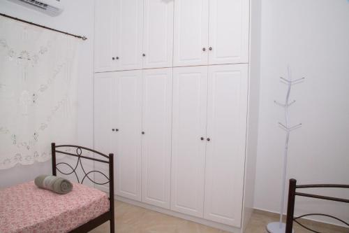 a white bedroom with white cabinets and a bed at Sunrise Bay in Panteli