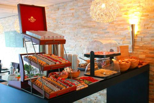 - un buffet avec des hot-dogs et d'autres aliments sur un comptoir dans l'établissement De Herbergh van Flielant, à Oost-Vlieland