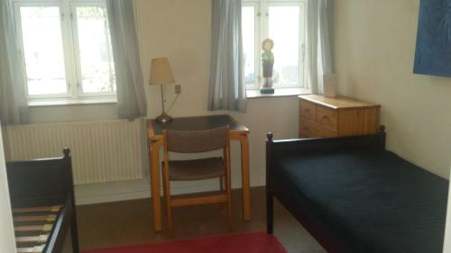 1 dormitorio con escritorio, 1 cama y 1 silla en Gamby fattiggård en Gamby