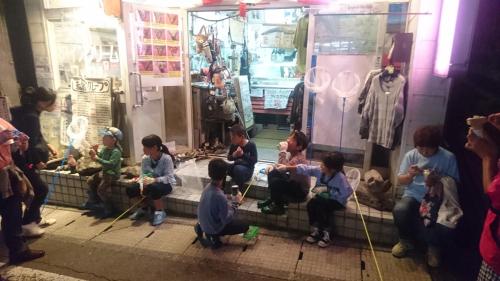 a group of people sitting in front of a store at Hotel Mumon in Myoko