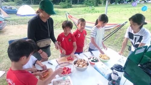 a group of children standing around a table with food at Hotel Mumon in Myoko