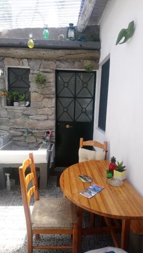 a room with a table and chairs and a bath tub at A Casa da Avó... in São Vicente