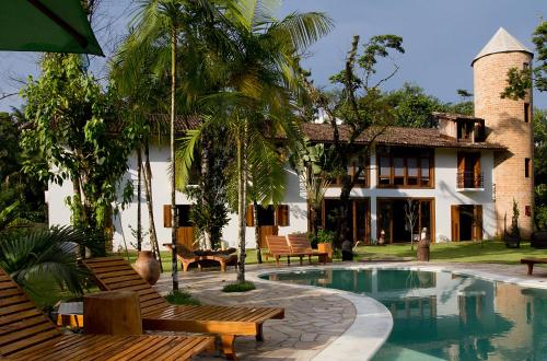 a resort with a swimming pool and a house at Estalagem Camburi in Camburi
