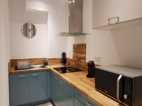 cocina con encimera, microondas y fregadero en Coeur Vieux Port tout équipé, en Marsella