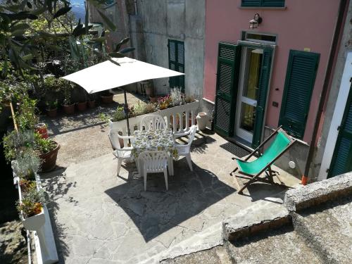 een patio met een tafel en stoelen en een parasol bij Casa Burrasca in Levanto