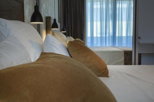 a bedroom with a bed with pillows and a window at Mirabilis Residence in Zadar