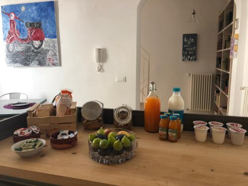 a table with a bowl of apples and bottles of juice at Itaca Home to Explorers in Polignano a mare in Polignano a Mare