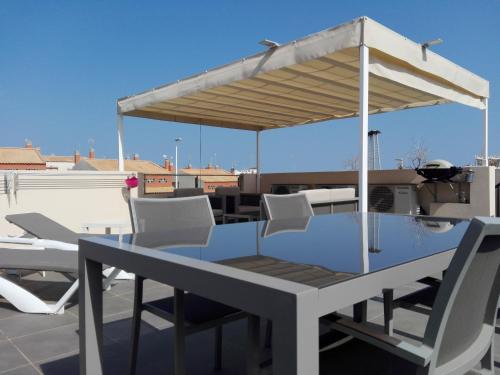 a table and chairs under a pavilion on a roof at Residencial Sabrina Penthouse in Playas de Orihuela