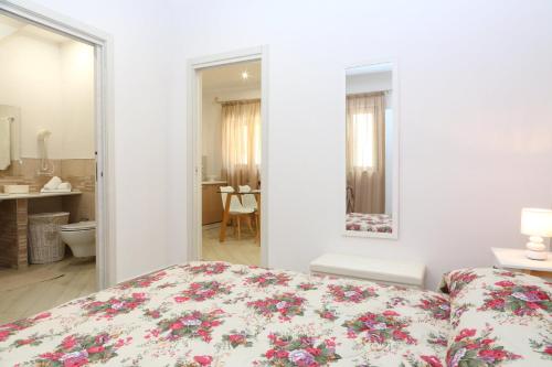 een slaapkamer met een bed met een bloemenbed bij La Casetta del Borgo Cefalù in Cefalù
