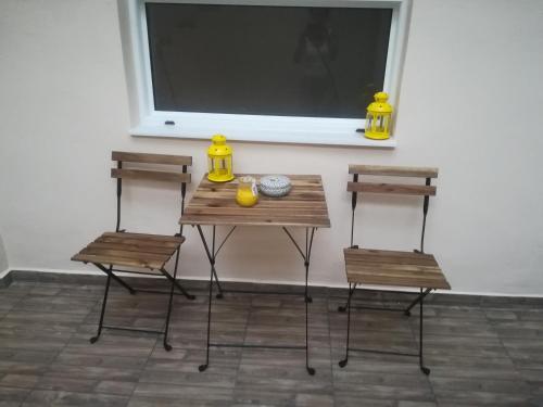 a wooden table with two chairs and a window at Port's little gem in Piraeus