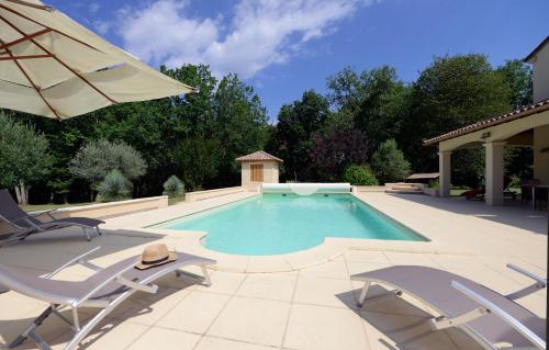 une piscine avec deux chaises et un parasol dans l'établissement Villa 