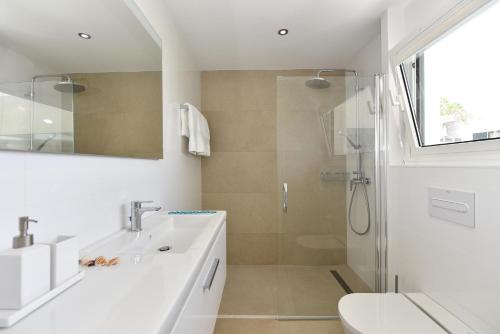 een witte badkamer met een wastafel en een douche bij Blue Ocean Villa Maspalomas in Maspalomas