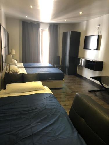 Habitación de hotel con 2 camas y TV de pantalla plana. en Concept Suites, en Alicante