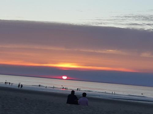 two people sitting on the beach watching the sunset at le vergoyer in Calais