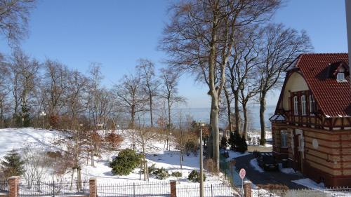 a house in the snow next to a fence at Hotel Fortuna in Heringsdorf
