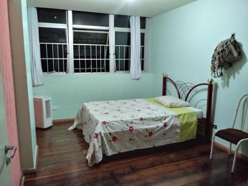 1 dormitorio con 1 cama con mesa y ventana en Juliana, en Recife