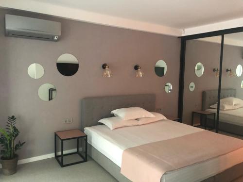 a bedroom with a bed and mirrors on the wall at StanGret Hotel in Kyiv