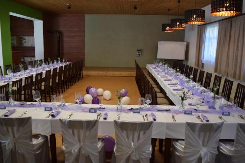 a row of tables in a room with white table cloths at Penzion Slunečno in Dobšín