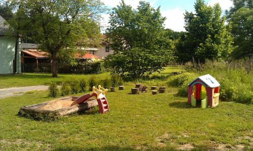 a toy park with a playground in the grass at Penzion Slunečno in Dobšín