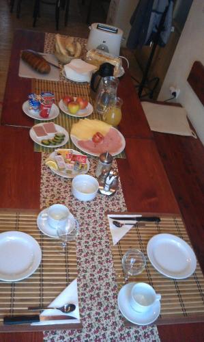 a wooden table with plates of food on it at Penzion Slunečno in Dobšín