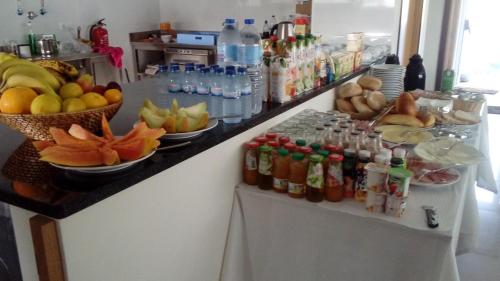 a counter with bottles of drinks and fruit on it at Pousada Tires Guest House in São Domingos de Rana