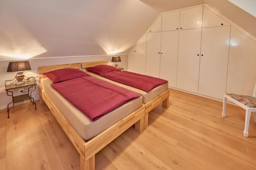 Un dormitorio con una gran cama de madera con sábanas rojas. en Ferienwohnung Haaren, en Waldfeucht