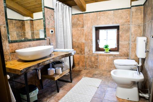 uma casa de banho com um lavatório e um WC em Agriturismo Magnarosa em Barge