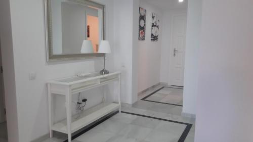 ein weißes Badezimmer mit einem Waschbecken und einem Spiegel in der Unterkunft El Velerín in Estepona