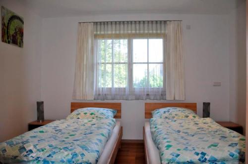 1 dormitorio con 2 camas frente a una ventana en Gästehaus Walser, en Unterbrunn