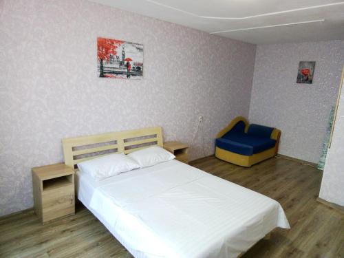 キーウにあるApartment on Kharkovskoe Shosse 170 bのベッドルーム(白いベッド1台、青い椅子付)
