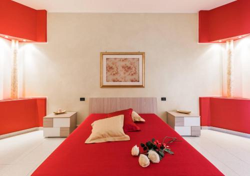 Un dormitorio con una cama roja con flores. en Cozy Nest, en Cassano delle Murge